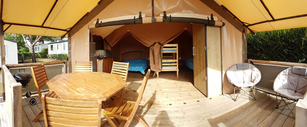 Une tente aménagée avec 2 chambres, un coin cuisine et un wc.

