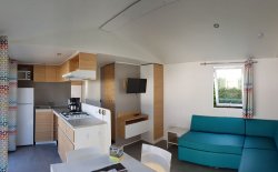 Coin salon et cuisine d’un mobil home 6 à 8 personnes 3 chambres équipé de télévision et lave vaisselle.
