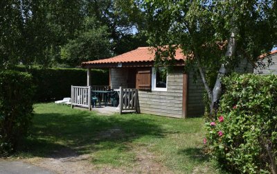 Vue extérieur d’un chalet pour 4 à 5 personnes avec terrasse semi couverte en camping 4 étoiles.
